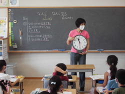 学級担任が、「何時」と「何時半」について説明している写真