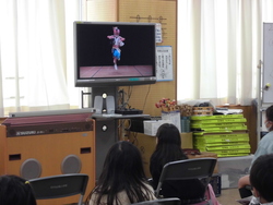 児童がねぶた囃子で踊る映像を見ている写真