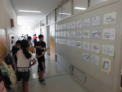 子どもたちが廊下に掲示された作品を見ながら、鑑賞カードに記入している写真