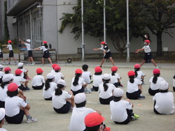 学級の代表の児童が、みんなの前で踊りを披露している写真