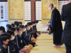 警策という棒で背中を叩かれている写真