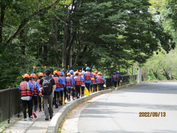 ラフティング体験を行う川まで歩道を歩いている写真