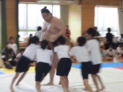 グループでお相撲さんに挑戦している写真