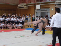 先生がお相撲さんを投げ飛ばしている写真