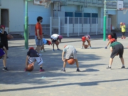 校庭でバスケットボールを扱う4年生