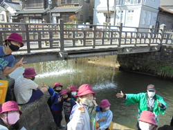 水が流れるジャージャー橋を喜ぶ児童