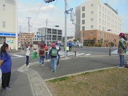 下校途中の横断歩道で安全な渡り方を呼びかける様子