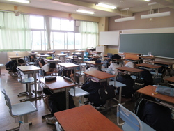 クラス全員が机の下に入っている写真