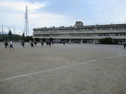 昇降口から校庭に向かって走る生徒の写真