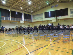吹奏楽部の演奏で新入生が退場している写真