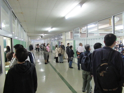 廊下から授業の様子を参観する保護者の写真