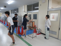 生徒が廊下で一人ずつ投票箱に投票している写真