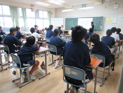 学級で選挙管理委員が投票の仕方を説明している写真