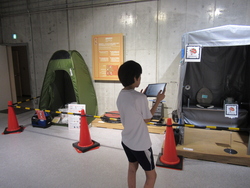 GRコードにタブレットをかざして、避難所生活の情報を学んでいる写真
