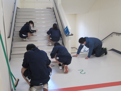 階段を雑巾で拭いている写真