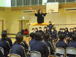 スラックラインの上で開脚して静止している写真