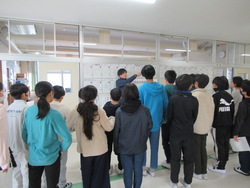 中学校の教員が校舎内を案内している写真