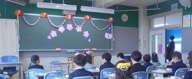 新しい教室で新入生が座っている写真