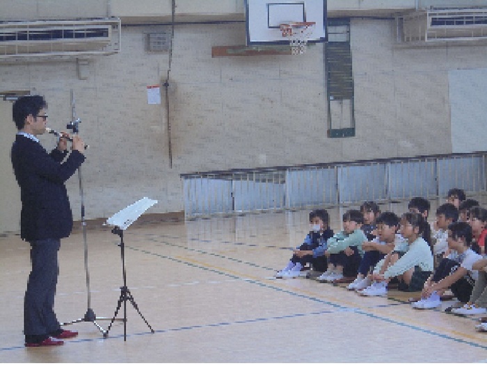 リコーダーを演奏しているのを子供たちが聞いている写真