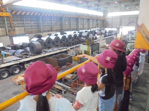 村山鋼材で機械が動くところを小学生が見学しているところ