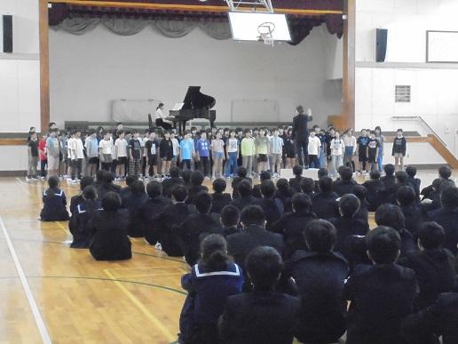 舞浜小の6年生が歌っているのを中学生が聞いているところ